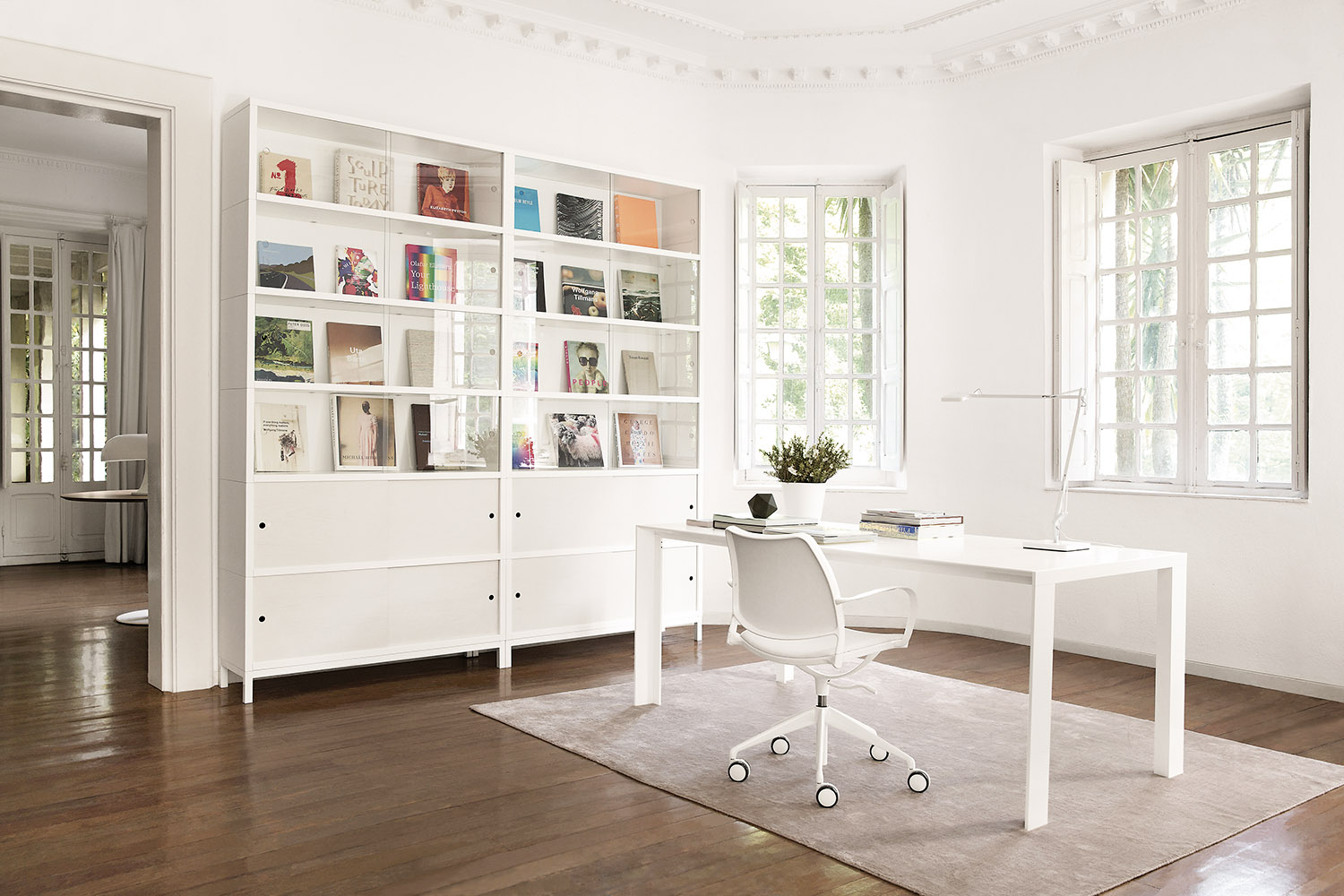 Despacho luminoso con amplia libreria y escritorio en blanco